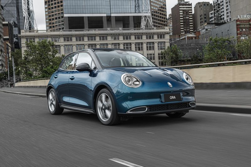 Front three-quarter view of the GWM Ora travelling on a inner-city road.